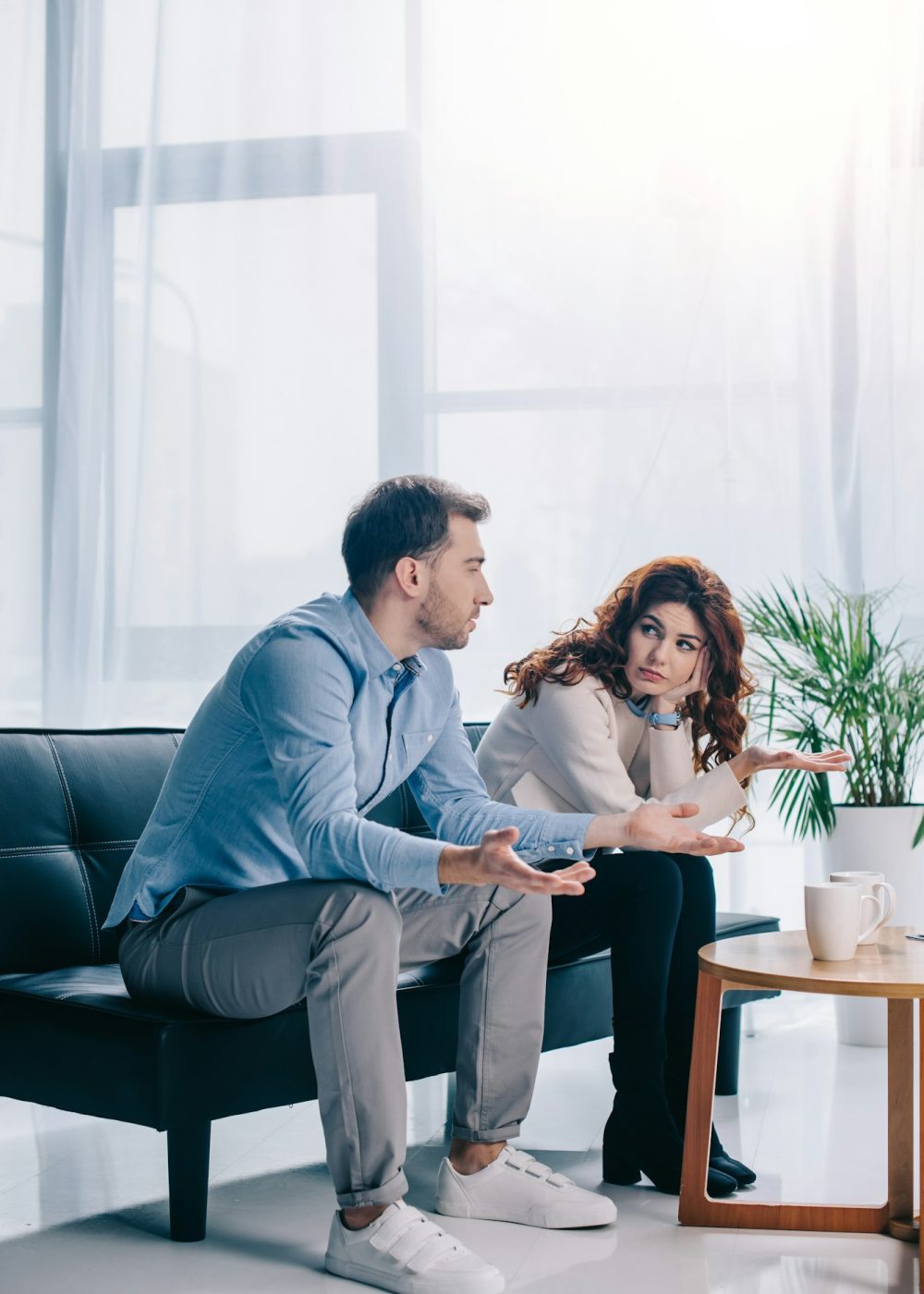 Divorcing young couple arguing in psychiatrist office